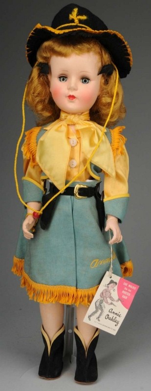 Rare American Character "Annie Oakley".: American, 1954. All hard plastic walker, original blonde hair, blue lashed sleeping eyes, closed mouth, rosy cheeks. Factory original outfit, fringed blue culottes, satin scarf, black felt hat, boots,