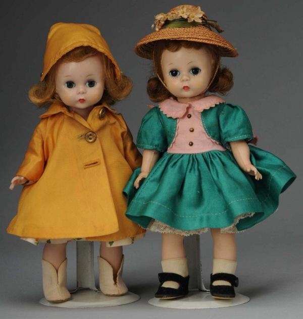Lot of 2: Madame Alexander Plastic Wendy Dolls.: American, Ca. 1950s. All hard plastic, bent-knee walkers. Wendy in tagged green dress with pink trim Sunday Outfit, undies, hat, shoes and socks; Wendy in tagged "Rain or Shine" outfit (a little dusty