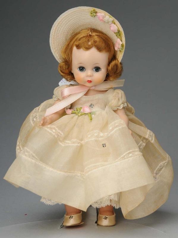 Sweet Madame Alexander Wendy.: American, Ca. 1954. All hard plastic, straight leg walker, blonde hair, dark eyes. All original in tagged cream voile gown and flower trimmed straw bonnet. 8" T. (Excellent).