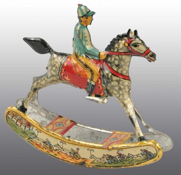Tin Litho Rocking Horse Penny Toy.: German. Very colorful lithography. Depicts jockey riding horse on rocker. Variation with race scenes lithographed on base of rockers. Some minimal wear to bottom edge of rockers. 3 - 1/2" T. (Excellen