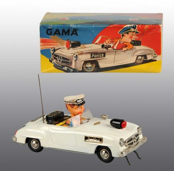 Tin Police Car Battery-Operated Toy.: German. Working. Marked "Gama" and "Made in Western Germany". Driver's head is composition. Car is a Mercedes. Some chipping to hat. Includes colorful original box with some creasing. 9" L. (Very Good