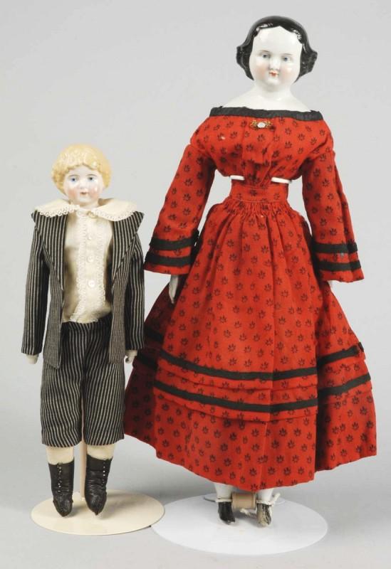 Lot of 2 German China Head Dolls.: Lady with 1860s molded black hair with modified flat-top hairstyle with smooth crown and finger curls all around, shaped 1-stroke eyebrows, light blue painted eyes, red eyelid line, black eyelash line