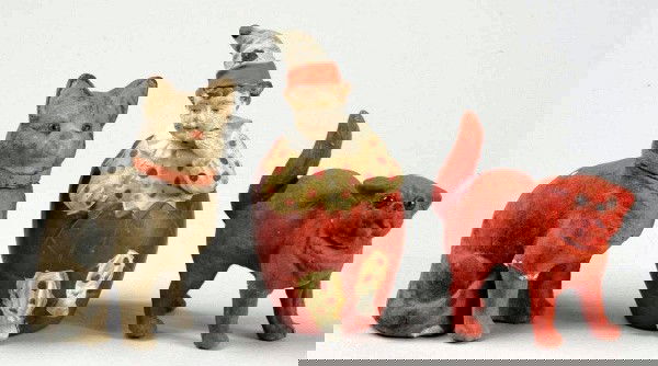 Lot of 3: Molded Composition Candy Containers.: German. Two flocked cats with glass eyes, both open at neck (one with reglued leg). Clown sitting in an egg, opens at bottom (cracks on arm and around neck, wear on face). Largest: 4 - 1/2" T. (Good).