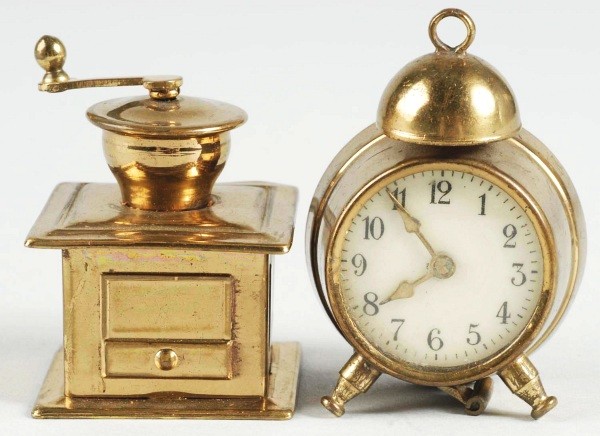 Lot of 2: Figural Tape Measures.: German. Both brass and windups. Includes a clock and coffee grinder. Size: 2".