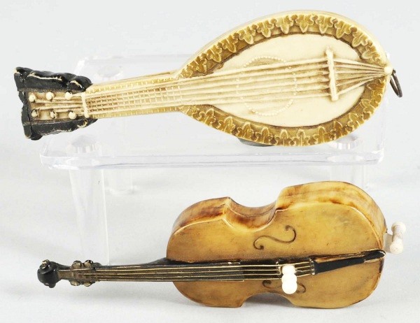 Lot of 2: Figural Tape Measures.: German. Celluloid. Includes a spring wound mandolin and violin wound by center knob. Size: Largest: 3 - 3/4" L.