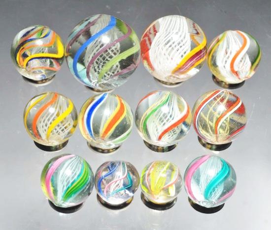 Lot of 12: Assorted Latticino Marbles.: Nice group latticinos. Includes two yellow and ten white, all in various colors. Size: Range: 1/2" to 15/16" Dia.