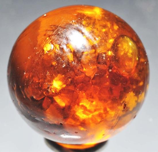 Single Pontil Mica Marble.: Golden honey amber single pontil with a nice cloud of mica inside marble. Hard-to-find in a single pontil. Marble has some small imperfection indentations. Size: 7/8" Dia.