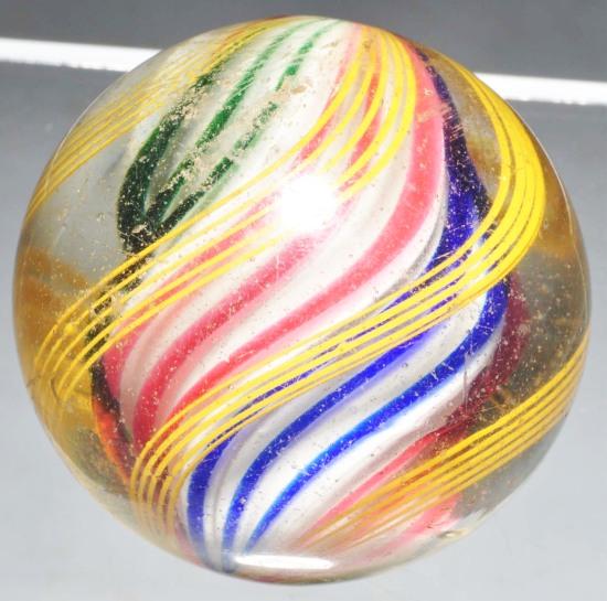 Large Solid Core Swirl Marble.: Fat solid core of white with opposite panels of three bands of pink, three bands of green and three bands of blue. Outer bands are groups of yellow latticino bands. Shallow chip at center. Size: 2" Di