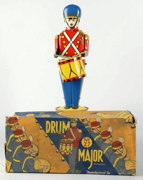 Tin Litho Wolverine Drum Major Wind-Up Toy.: American. Working. Bright and colorful lithography. Some slight scratching and wear. Includes colorful and complete original box and inserts. Box is marked "No. 27 Drum Major", has one outer flap that