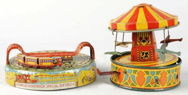 Lot of 2: Tin Litho Vehicle Wind-Up Toys.: American. Includes one early version Marx Honeymoon Express and one lever activated Wyandotte Carousel with four tin airplanes that move around base. Both toys with some scratching and wear. Size: Lar