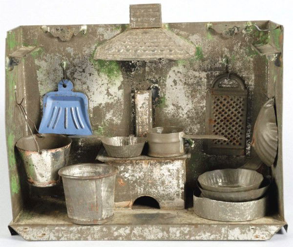 Early Tin Kitchen Diorama Toy Set.: American. Includes backdrop with hooks to hang accessories like a shovel, grater, pots, etc. and stove with chimney. Overall paint loss and wear. Size: 8 - 1/2" L.
