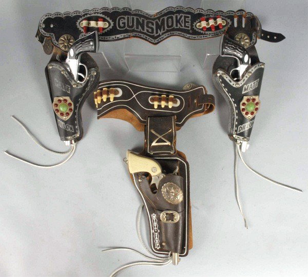 Lot of 2: Gun & Holster Sets.: Includes one Matt Dillon set and one Wyatt Earp set. Guns are not Gunsmoke, Wyatt Earp gun is fired, and holster has repair. Size: Largest: 10 - 1/2" L.
