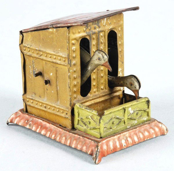 Tin Litho Animal Penny Toy.: German. Hand crank toy. Marked "Gesch" in embossed letters on bottom of toy. When in operation, two hens peck at feed box. Some pitting and oxidation to metal on roof and some overall wear. Size: 2" T