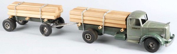 Pressed Steel Smith-Miller Lumber Truck Toy.: L mack front with bulldog hood ornament. Bumper and headlights are intact. Decals on sides of cab have some chipping, replacement chains and wood loads, and some chipping throughout cab. Size: 37" L.