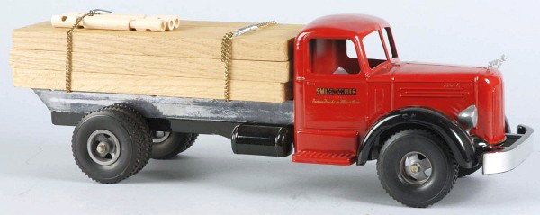 Pressed Steel Smith-Miller Lumber Truck Toy.: American. Bulldog hood ornament and dual black rubber tires. Smith-Miller decals on both side doors. Truck has been professionally restored and has new chains and load of lumber. Size: 19" L.