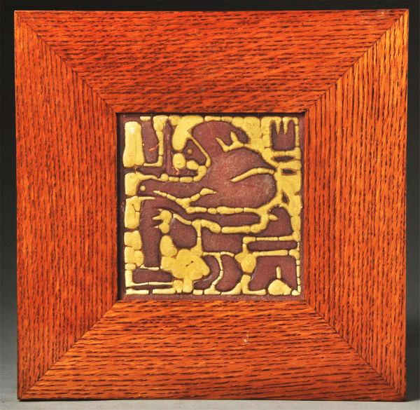 Grueby Red Clay 2-Color Faience Tile.: Depicts an occupational tile of a man plying his trade. Minor glaze loss in two places on brown spots. In a contemporary oak frame. Size: Framed: 11 - 3/4" x 11 - 3/4".
