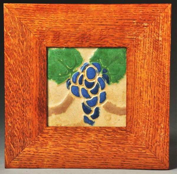 Grueby 4-Color Faience Tile.: Depicts grapes. Grease under a crazed glaze in the light brown color. In a contemporary oak frame. Size: 11 - 3/4" x 11 - 3/4".