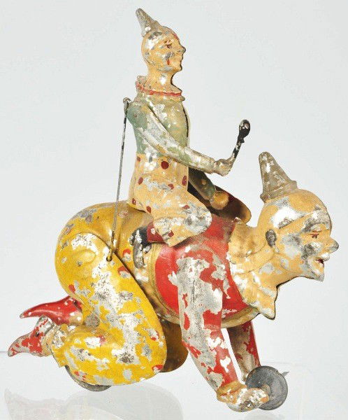 Tin Gunthermann Clown Riding Clown Wind-Up Toy.: German. Working. Scarce toy. When in operation, clowns right arm is articulated. Moderate paint flaking and loss throughout. Size: