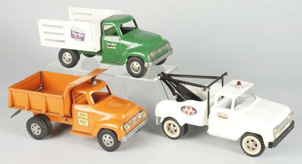Lot of 4: Pressed Steel Tonka Trucks.: Includes a highway department dump, a Starkist Foods Inc. truck, an AAA Tonka wrecker, and a #20 hydraulic dump truck in its original box. All trucks are very complete with play wear. Size: Largest: 1