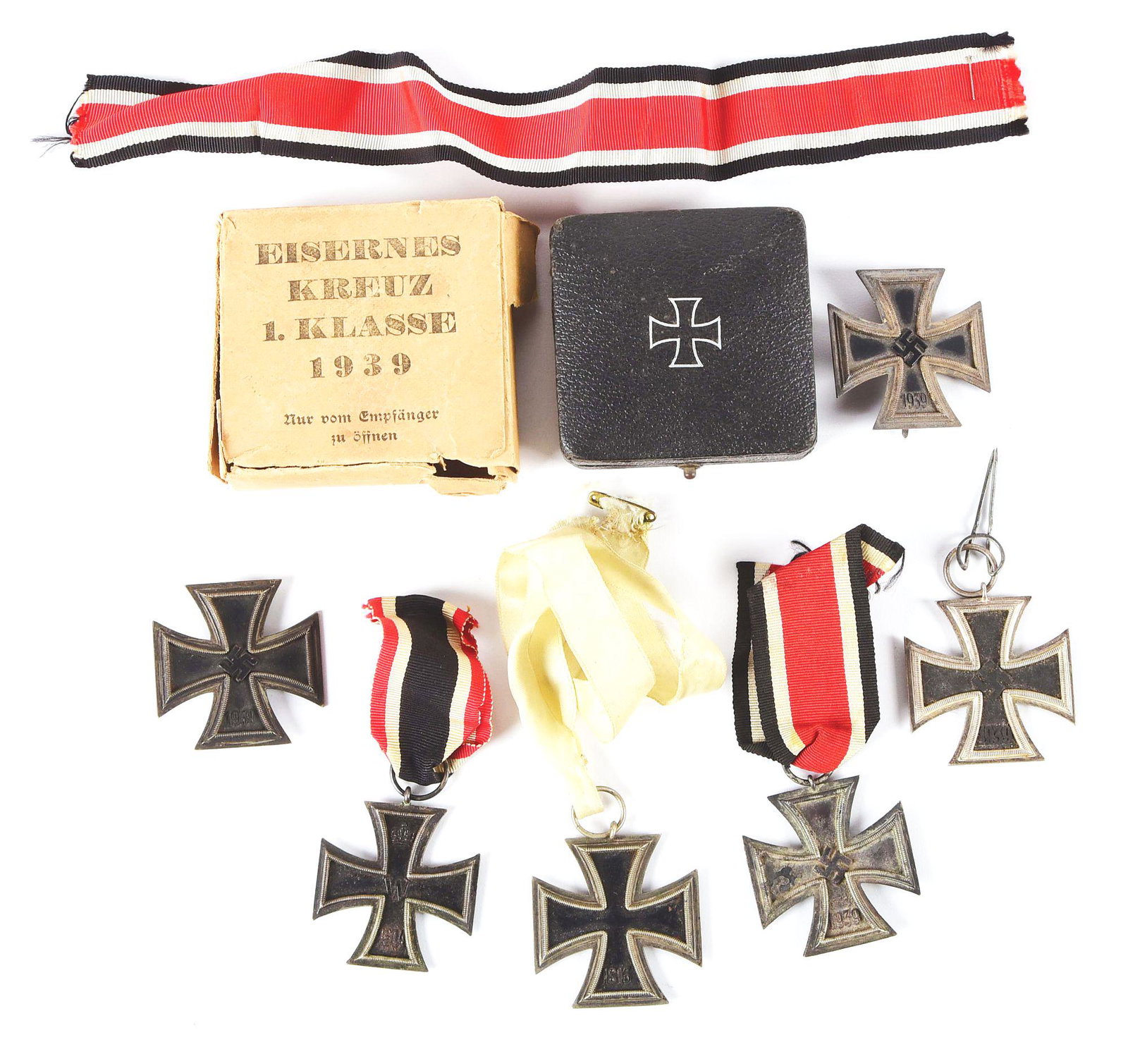 LOT OF 7: WWII IRON CROSSES INCLUDING A CASED AND BOXED: Lot consists of: (A) German World War II Iron Cross 2nd Class with a “65” marked ring and light patina throughout. A small dent to the top of the frame can be seen. CONDITION: Very good. (