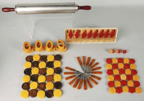 Large Lot of Bakelite Pieces.: Includes one handled rolling pin in original cardboard box, two sets of checkers, one set of eight corn holders in red, one small dinner bell, one set of eight butterscotch napkin rings, and other ite