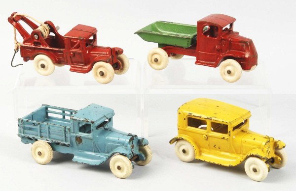 Cast Iron Arcade No. 3440 Vehicle Set.: American. Circa 1930. Includes four vehicles consisting of one stake back truck, one tow truck, one dump truck, and one coupe auto. All are marked "Arcade" on underside in embossed letters and Arcade 