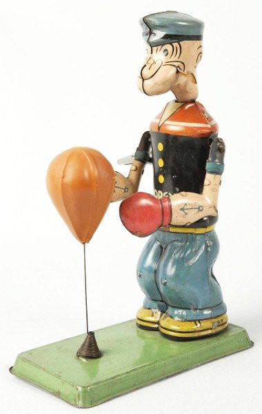 Tin Litho Chein Popeye Floor Punching Wind-Up Toy: American. Working. Marked "Popeye" across chest. Original celluloid bag. Head is detached but present. Base has some wear around edges and toy has some scratching throughout. May clean to a better gra