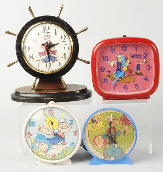 Lot of 4: Popeye Clocks.: Various makers. Includes two wind-up, one electric, and one battery-operated. Size:Largest: 7 - 1/2" T.