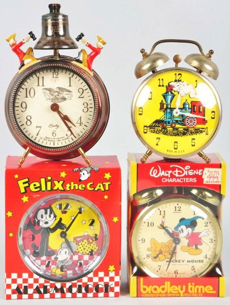 Lot of 5: Contemporary Character Clocks.: Circa 1970s to 1980s. Includes large Walt Disney World wall clock of Mickey Mouse, small Mickey and Pluto alarm clock sealed in box, small Felix the Cat sealed in box, one Locomotive Lux clock, and on