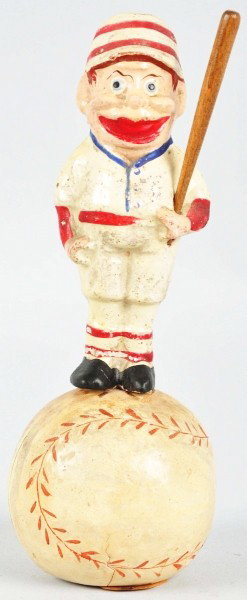 Rare & Unusual Baseball Mascot Candy Container.: Circa 1900. Player looks like a Palmer Cox Brownie dressed in an early baseball uniform, holding a wooden bat, and balanced on top of a baseball. Cardboard trap in bottom. Cracking to bottom of baseba