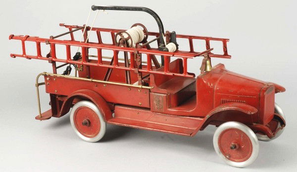 Pressed Steel Buddy L Hook and Ladder Fire Truck.: Description American. Circa 1925. Open front cab with brass bell and rear service body with rear step. Includes ladder racks with four ladders, original wrecking boom and hook, hose reel with replacem