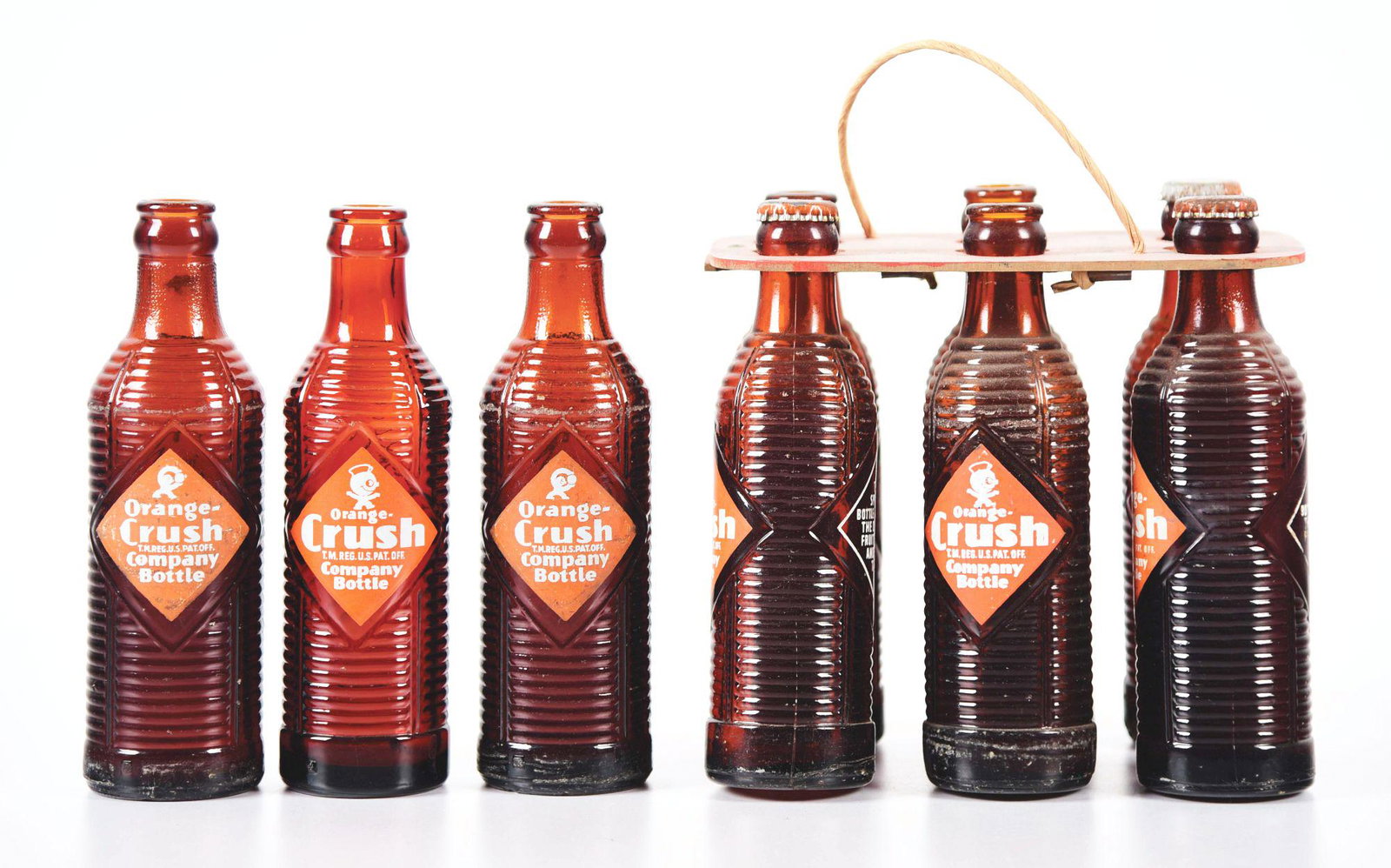 LOT OF 9: ORANGE-CRUSH GLASS BOTTLES.: Lot of nine Orange-Crush glass bottles. Six of them are in a wooden handheld carrier. All are ribbed bottles with only minor varying degrees of condition. Condition: (8.0). Item Dimensions: Largest: 8