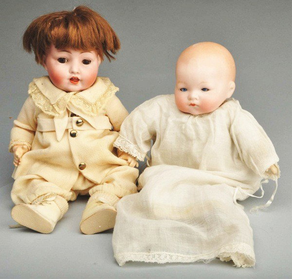 Lot of 2: German Bisque Head Baby Dolls.: One is a K&W 99 with brown sleep eyes on a five-piece composition bent limb body. Other is a flange neck AM 341 baby on cloth body with composition hands and blue sleep eyes. AM baby's eyes are slight