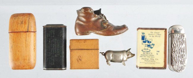 Lot of 7: Assorted Match Safes.: Includes one boot form, one with celluloid advertisement for Koken Barber Chairs, one with wooden hinge, one leather-covered box, one figural pig, one knife, and one leather-covered safe. Size: Larges