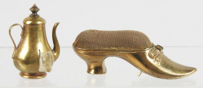 Lot of 2: Metal Figural Sewing Tape Measures.: Includes one wind-up teapot and one wind-up shoe with pin cushion. Both with full tape measures. Size: Largest: 3 - 1/4" L. Condition: (Excellent).