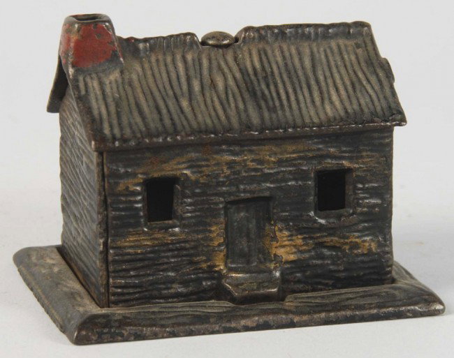 Cast Iron Log Cabin Still Bank.: Circa 1882. Manufactured by Kyser & Rex. Some overall wear. Size: 2 - 3/4" T. Condition: (Very Good - Excellent).