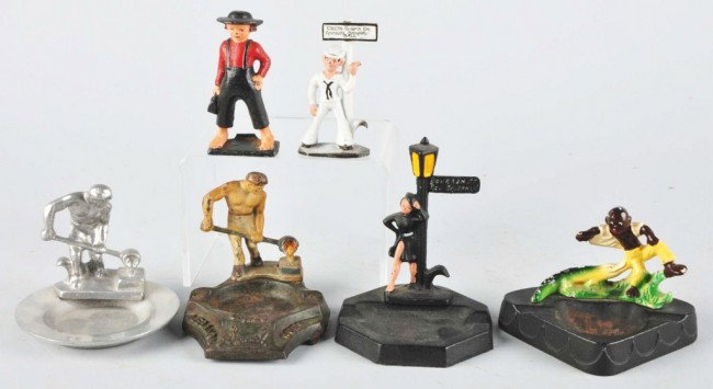 Lot of 6: Cast Iron Bottle Openers.: Four are mounted on ash trays. Includes two foundry men, one street walker, one boy with alligator (hands down), one sailor, and one Amish boy. Size: Largest: 5" T. Condition: (Very Good).