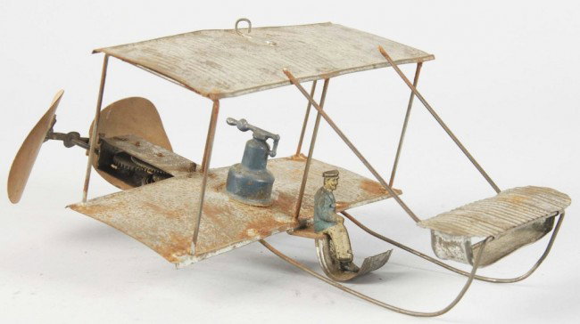 Handpainted Tin Bi-Wing Airplane Wind-Up Toy.: German. Working. Original pilot. Body of plane is bare metal with some areas of rust and no remnants of paint. Size: 8 - 1/2" L. Condition: (Very Good).