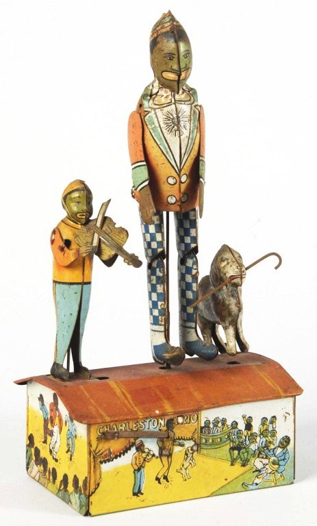 Tin Litho Marx Charleston Trio Wind-Up Toy.: American. Working. All original. Depicts African American dancer on roof, smaller man playing violin, and dog with can in its mouth. Nice lithography around base. Some pitting and fading, especially t