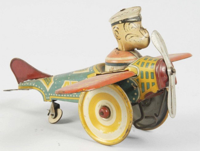 Tin Litho Marx Popeye the Pilot Wind-Up Toy.: American. Working. 1936 variation with original tail fin and propeller. Some scratching and fading to lithography. Size: 8" Wingspan. Condition: (Good - Very Good).
