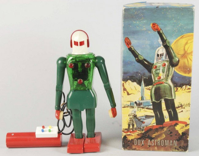 Plastic Dux-Astroman Battery-Operated Toy.: German. Working. Remote control. Marked "Made in Western Germany". When in operation, robot walks forward, bends up and down, swings arms, and open and closes arms to lift objects. Comes with original