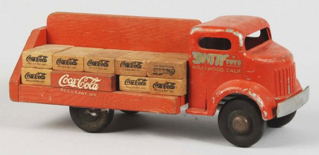 Coca-Cola Smith-Miller Toy Truck.: 1940s. Metal and wood with wooden blocks simulating the cases. Slight fading, medium overall wear, and some chips, nicks, and scratches. Size: 13 - 1/2" L. Condition: (Very Good).