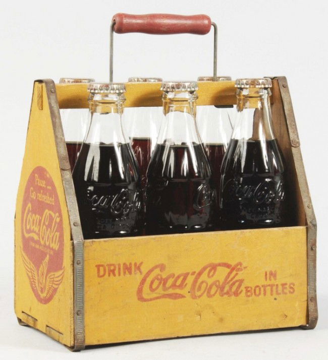 Wooden Coca-Cola Carrier & Bottles.: 1940s. Bottles are filled, capped, and from South America. Strong carrier with good remaining stencil on four sides. Only light soiling or wear. Size: 8" T. Condition: (Excellent).