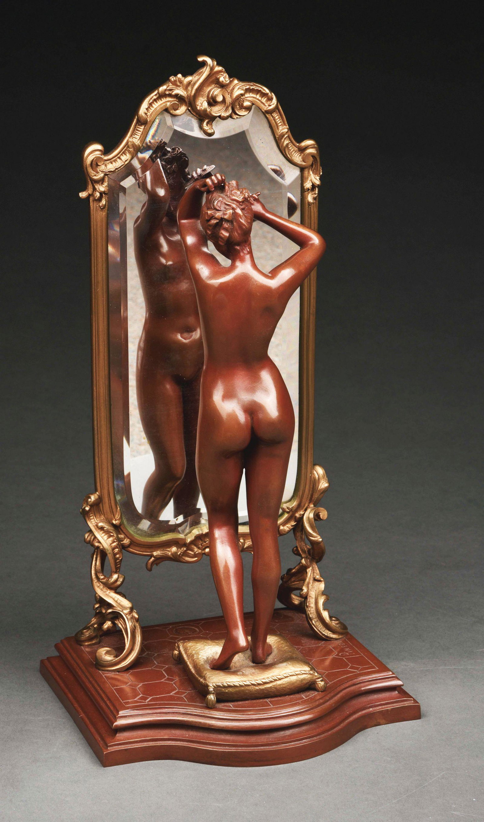 BRONZE NUDE "THE LOOKING GLASS" BY EMILE PINEDO.: This sculpture of a bronze nude standing in front of and gazing into a mirror is by Emile Pinedo. It is signed "Pinedo" on the base. Figure stands on top of a golden pillow that rests on the floor. Sh