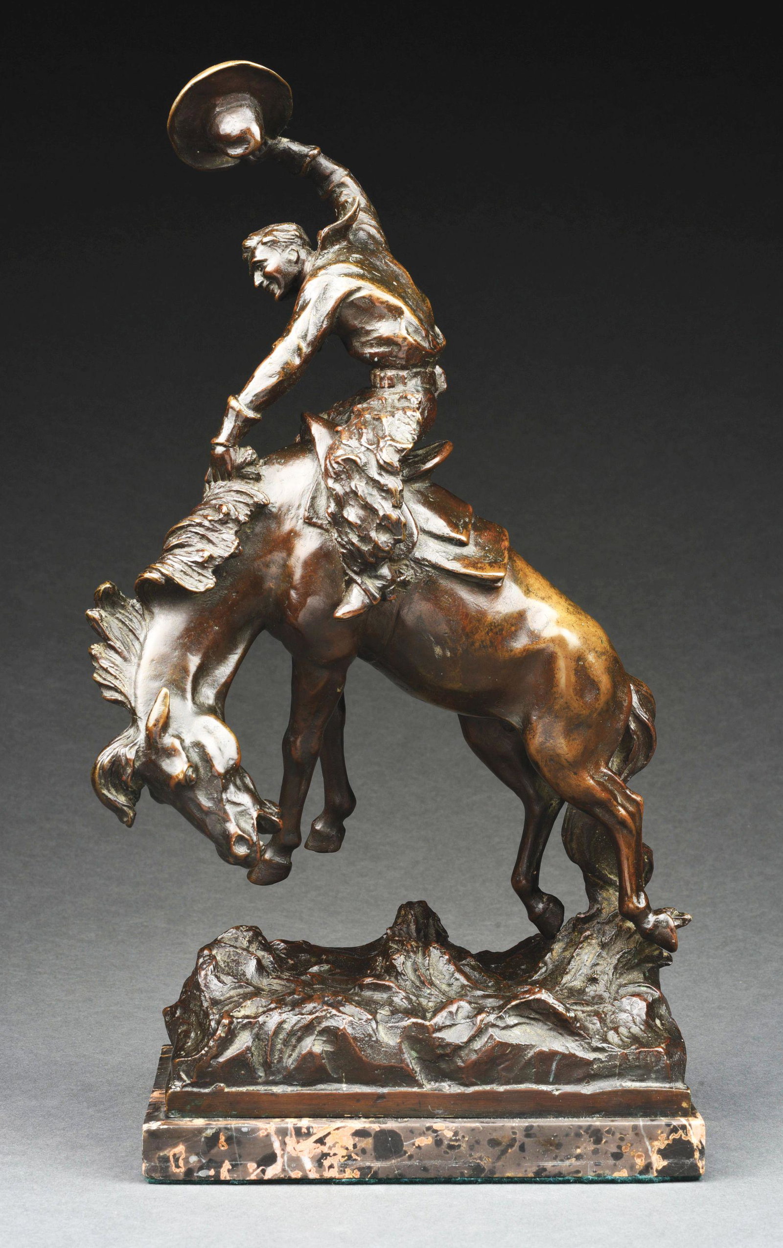 AFTER REMINGTON BY PROF. PALMIERI BRONZE COWBOY ON HORSE ON MARBLE BASE.: After Frederic Remington by Prof. Palmieri signed bronze sculpture of a cowboy on a horse, with brown patina on black-brown veined marble plinth. The sculpture is a wonderfully executed depiction of a