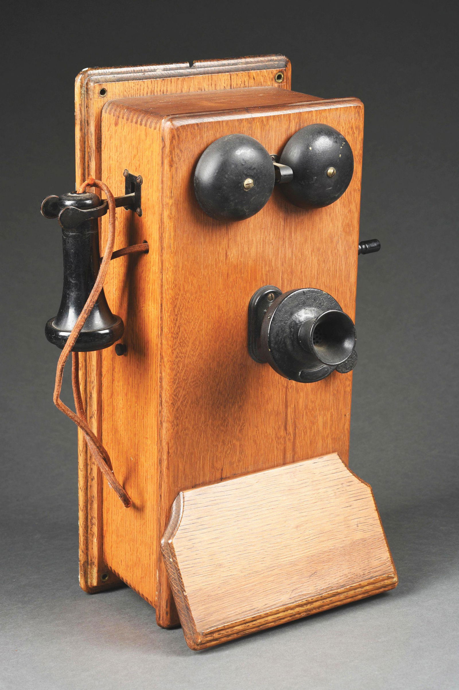 ANTIQUE OAK WALL TELEPHONE.: Antique oak wall telephone rings bell when wound, has dial mechanism inside and has receiver and speaker intact. Condition: (Excellent). Dimensions: 20 - 1/2" T x 9 - 1/4" W x 8 - 5/8" L.