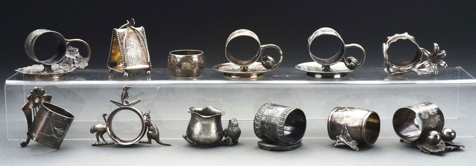LOT OF 12: VICTORIAN FIGURAL NAPKIN RINGS.: Lot of 12 Victorian figural napkin rings consists of: first, a triangular "Best Wishes" napkin ring with 2 wish bones by Meriden, 3"; second, a ring with harp-shape holder, 3"; third, a ring with fing