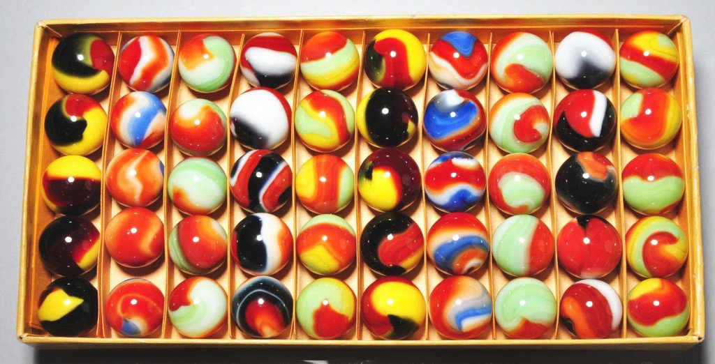 Akro Agate Red Box of 50 Tri-Color Marbles.: Unmarked box contains two rows of green, red, and yellow tri-colors, two rows of red, white, and black tri-color swirls, two rows of green, white, and red corkscrews, two rows of red, white, and blue 