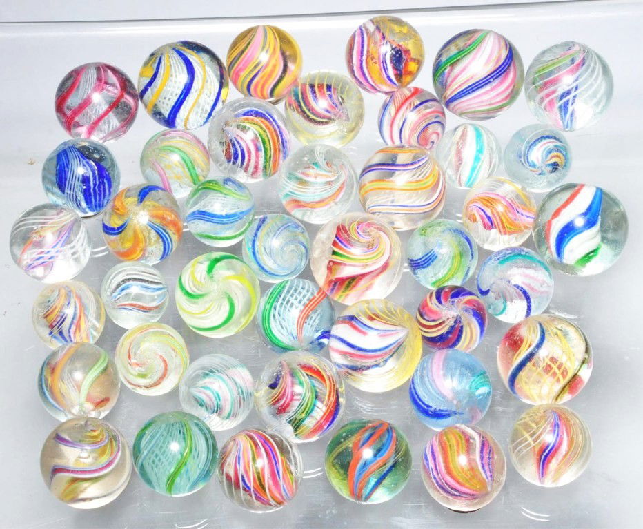Lot of 42: Assorted Swirl Marbles.: Includes 18 divided core swirls, eight solid core swirls, fifteen latticino swirls, and one three stage red jelly core. Two marbles are polished. Range: 5/8" to 7/8" Dia. Condition: (9.0).