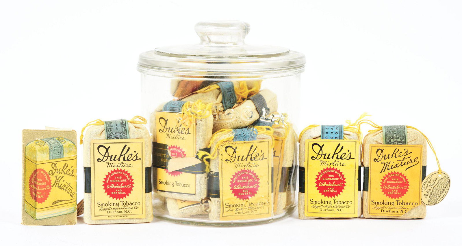 LARGE LOT OF FULL PACKS OF DUKE'S MIXTURE SMOKING TOBACCO.: This large lot consists of Duke's Smoking Mixture Tobacco pouches. It includes a glass humidor jar with about 12 pouches and an additional 3 outside the jar, some with their original bands, most with 